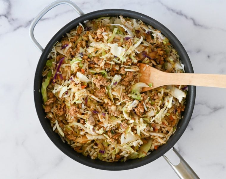 wilting coleslaw in skillet.