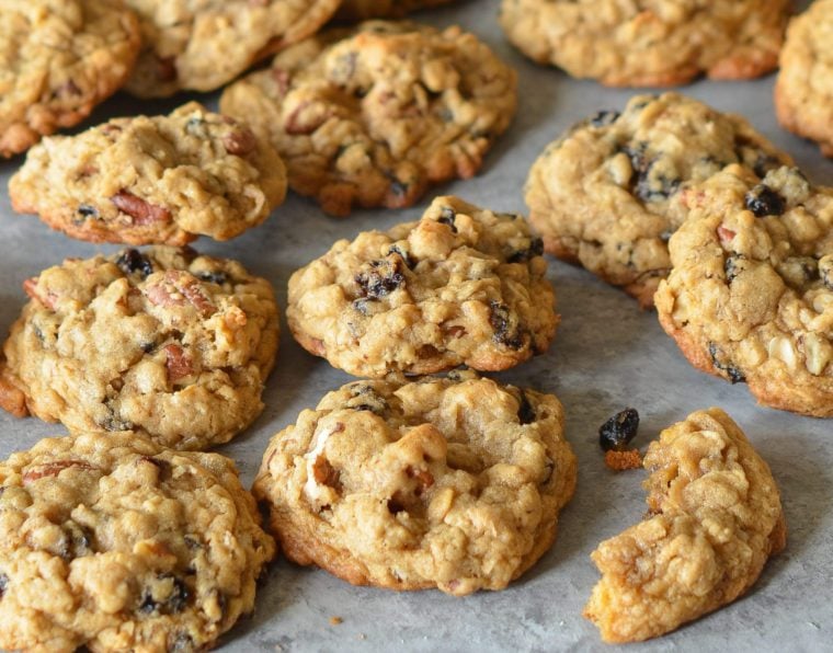 Oatmeal cookies with raisins and pecans on parchment paper.