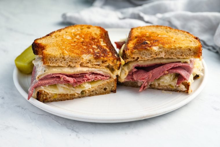 reuben sandwich on plate with pickle