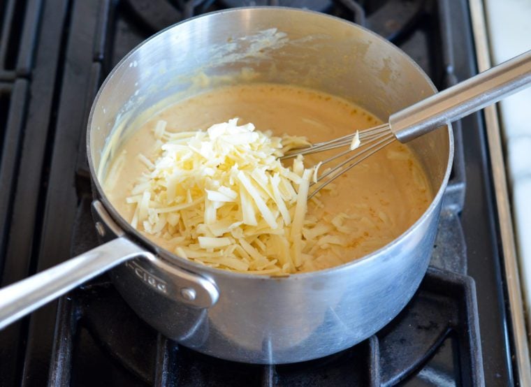 adding cheese to sauce