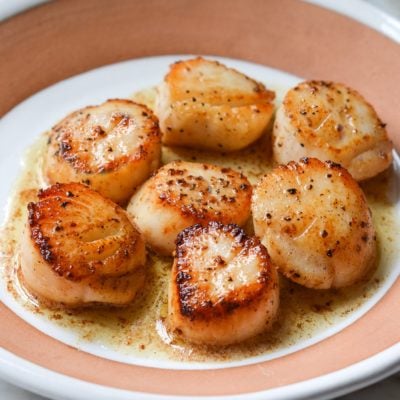Plate of pan-seared scallops with lemon butter.
