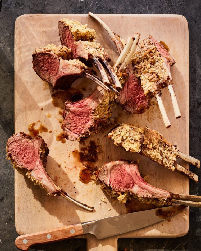 Lamb with Dijon and panko crust on a cutting board.