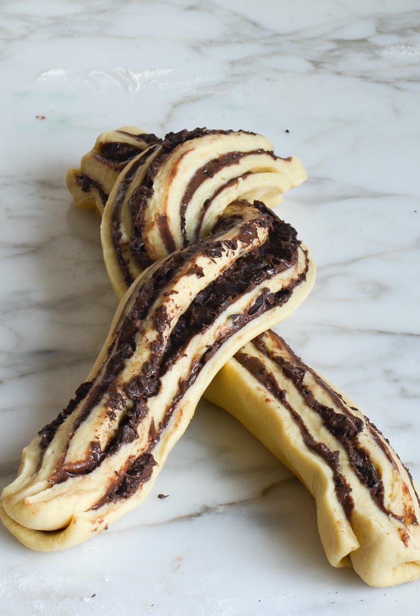 process of twisting the babka dough on marble.
