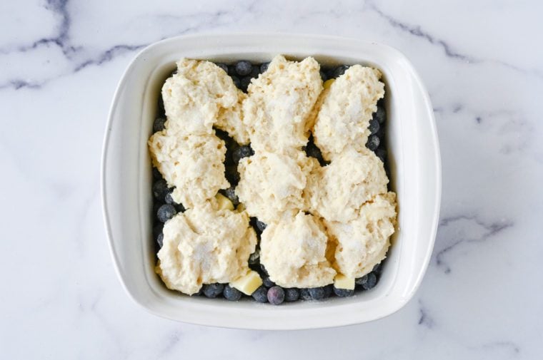 dolloped biscuit topping on top of blueberry mixture