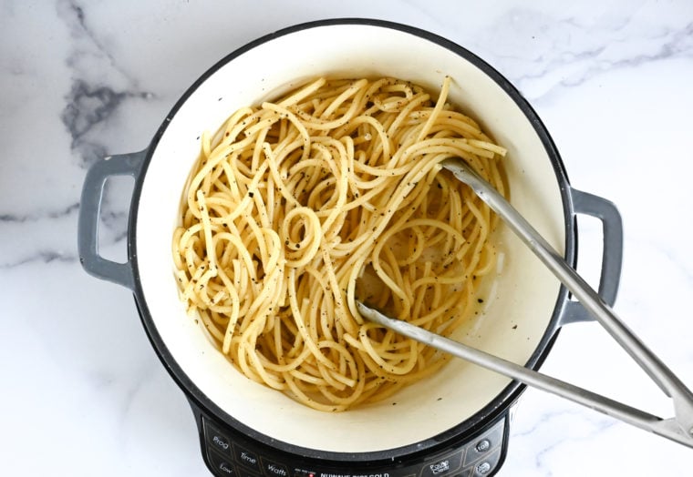 tossing pasta with butter and pepper