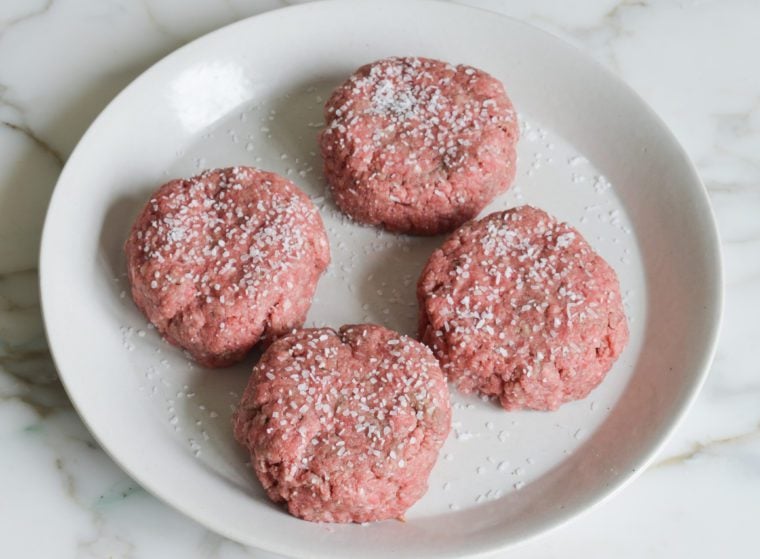 seasoning the smash burgers with kosher salt