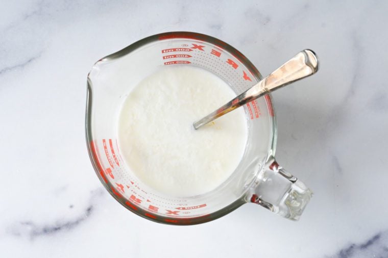 Spoon in a measuring cup of buttermilk.