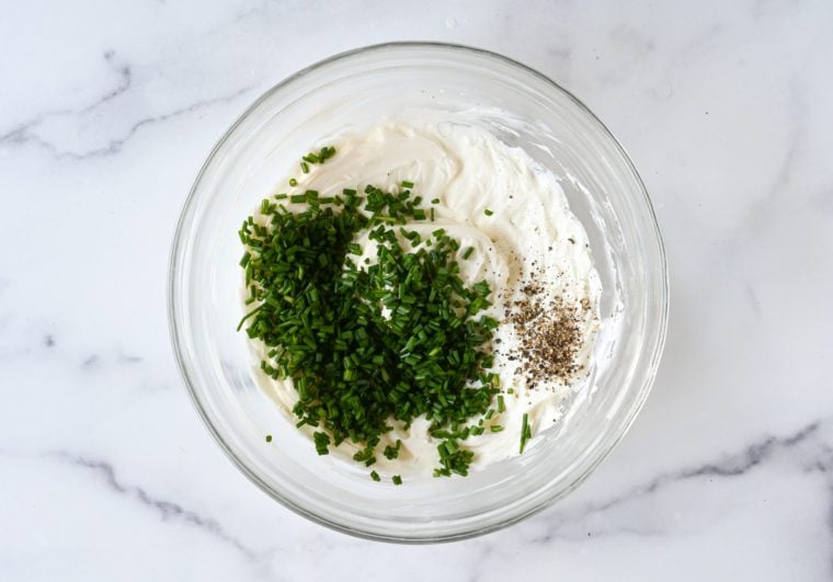 Seasonings in a bowl of schmear.