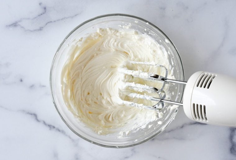 Electric mixer mixing a bowl of schmear.