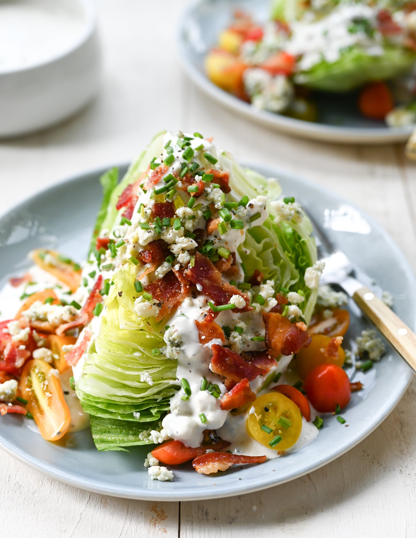Iceberg lettuce wedge salad on a plate with a fork.
