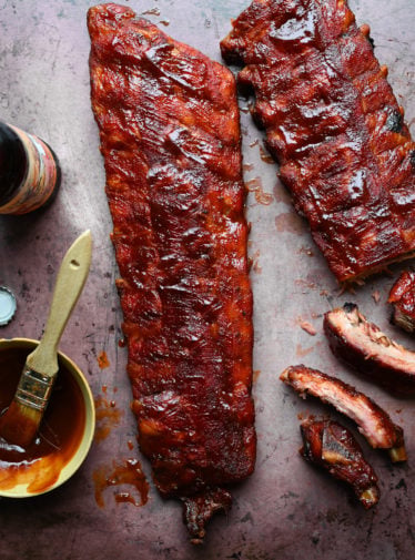 Bowl of barbeque sauce with baby back ribs.