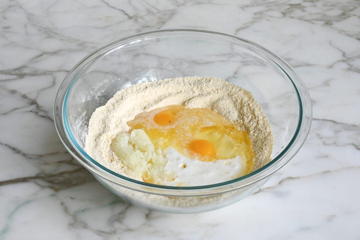 adding buttermilk, grated onion, eggs, and melted butter