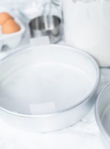 Pans with eggs and flour on a countertop.