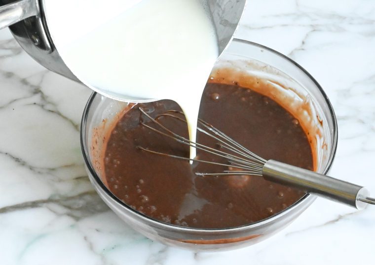 gradually adding milk and cream mixture to chocolate mixture