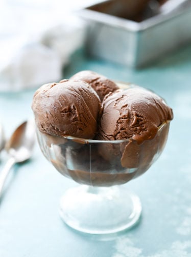 Three scoops of chocolate ice cream in a stemmed glass.