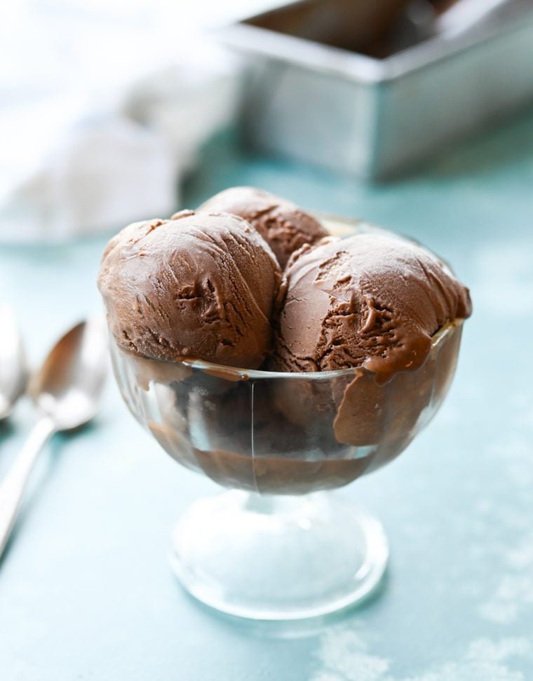 Three scoops of chocolate ice cream in a stemmed glass.