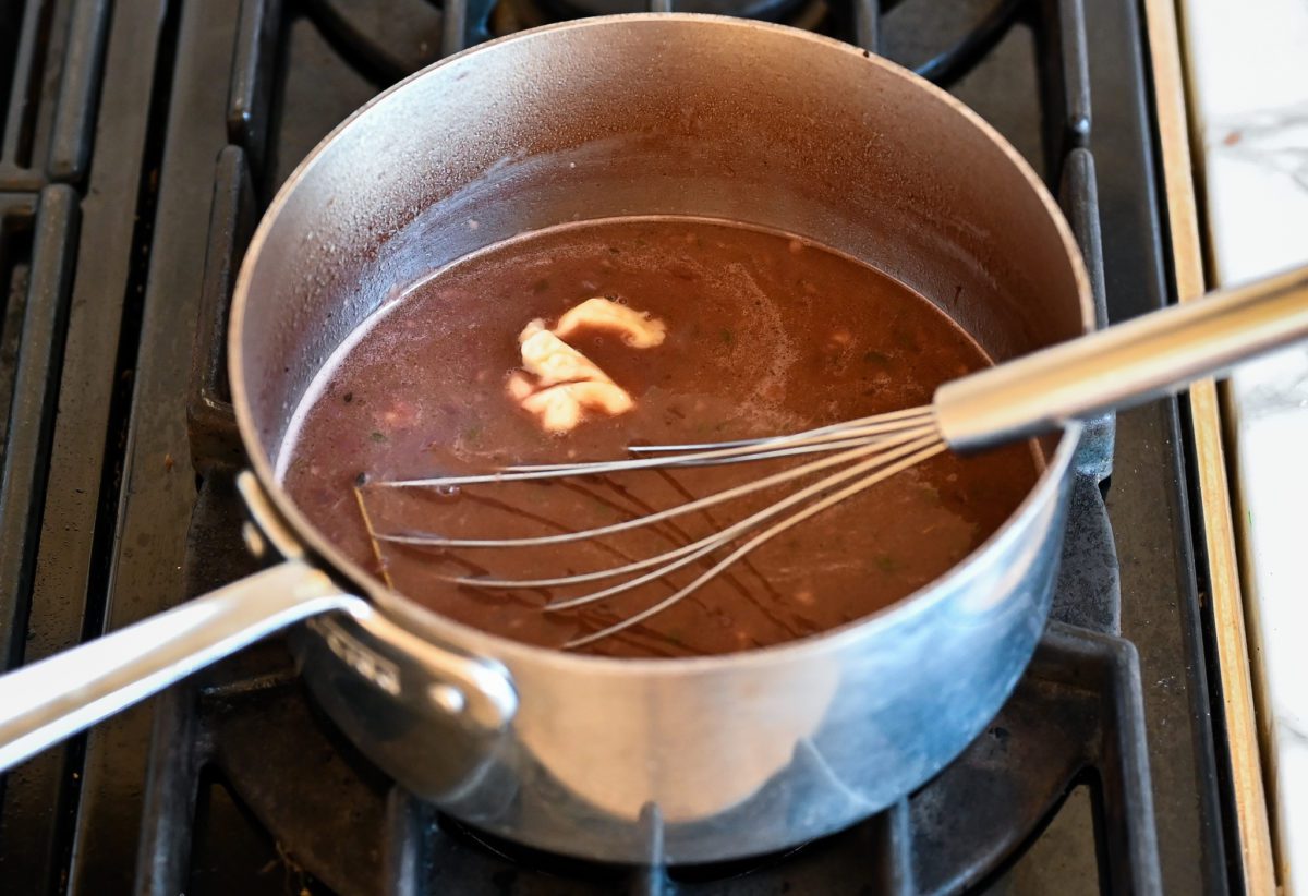 whisking the flour and butter paste into the sauce