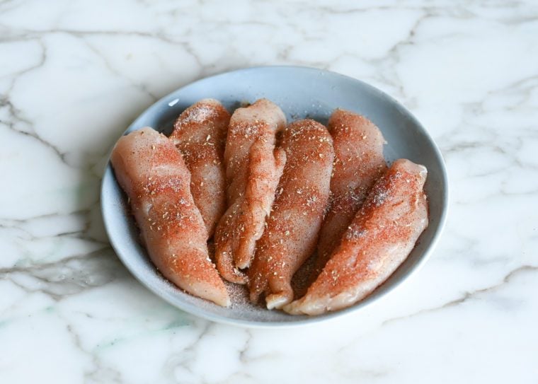 chicken tenderloins on plate seasoned with the spice rub