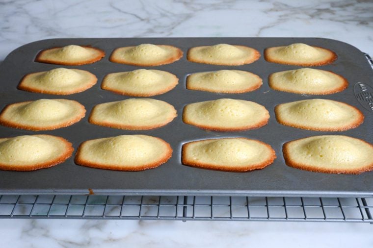 fresh baked madeleines cooling on rack