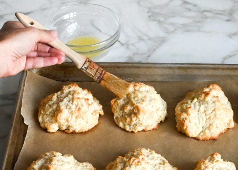 brushing butter on drop biscuits