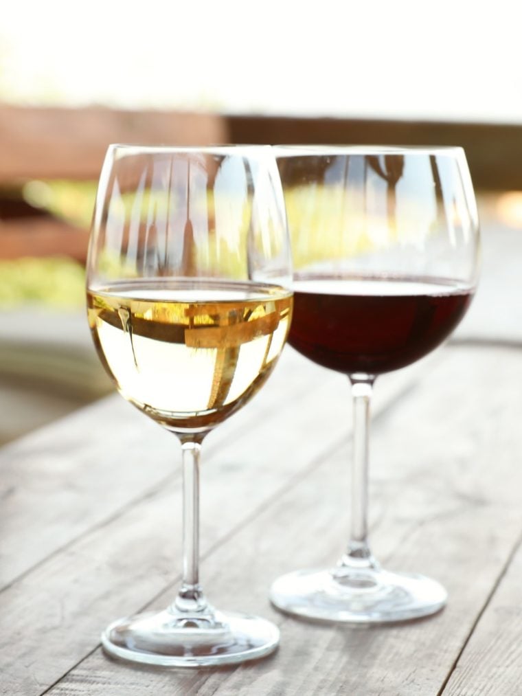 Glass of red wine next to a glass of white wine.