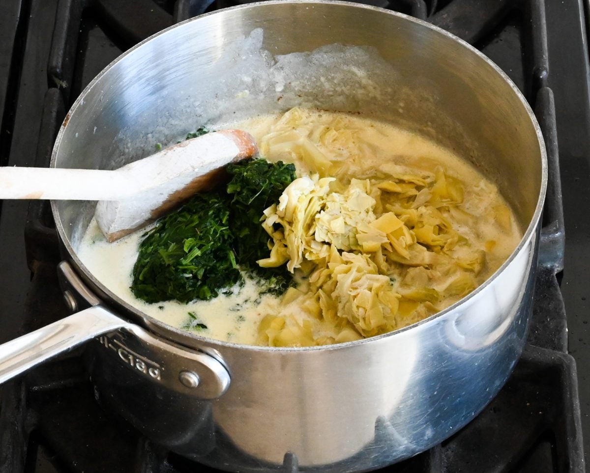 adding the spinach and artichokes.