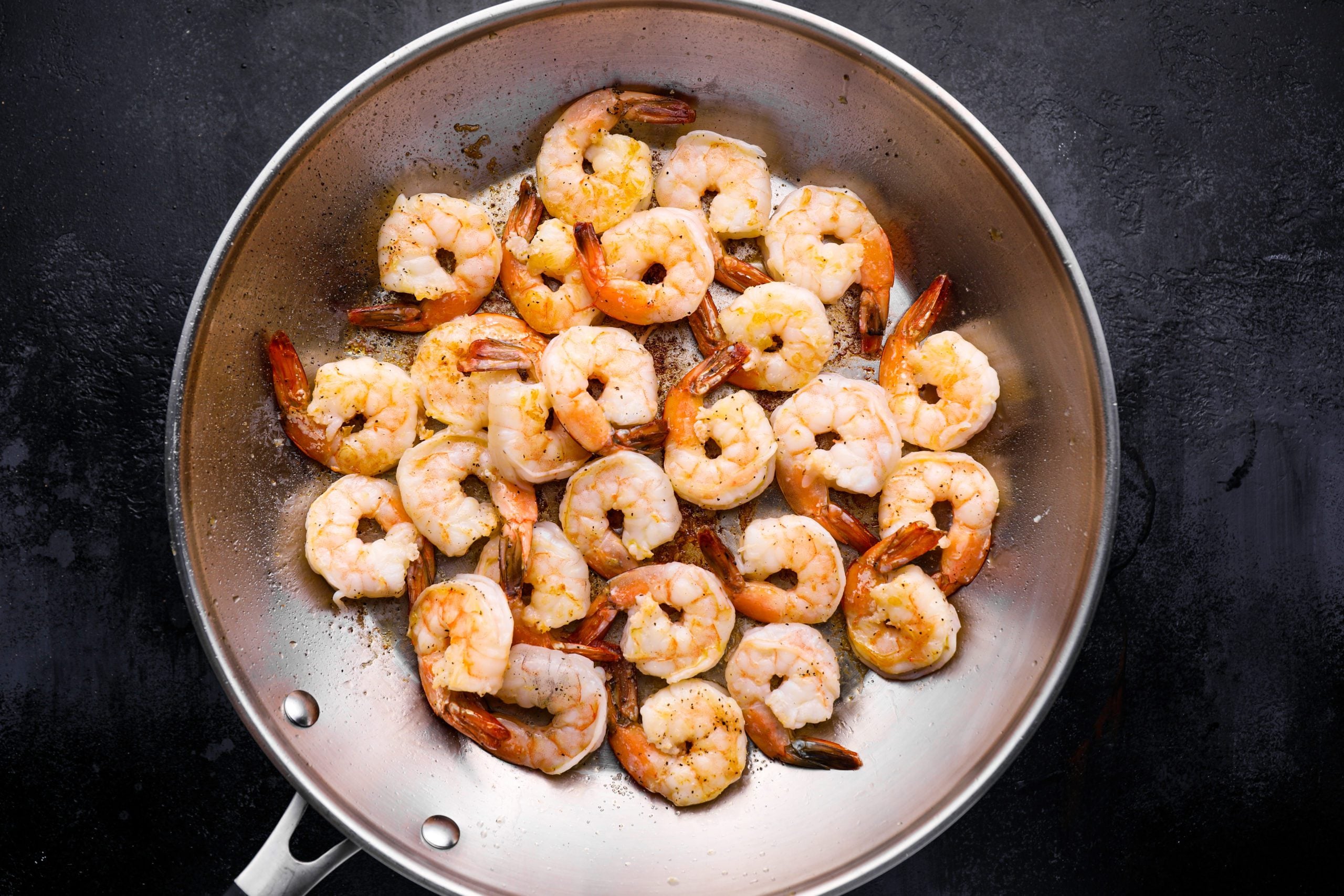 Shrimp cooking in a skillet.