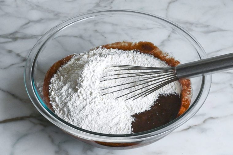 adding the flour mixture to the chocolate crinkle cookie dough