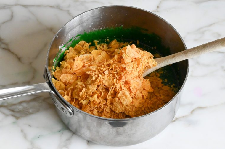 adding cornflakes to marshmallow mixture