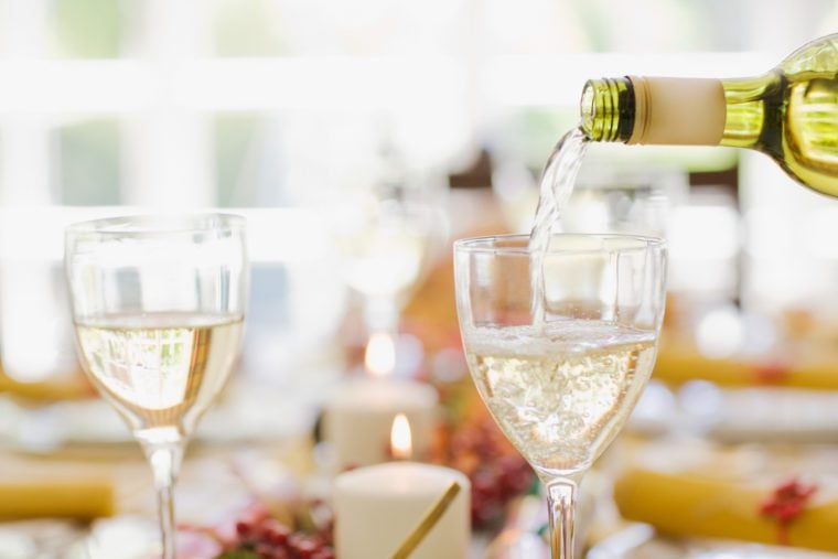Bottle pouring Reisling into a wine glass.