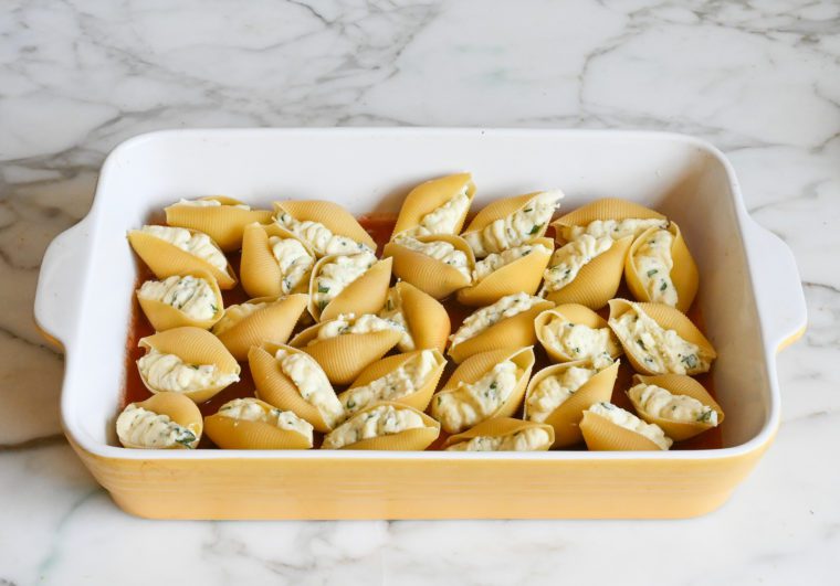 stuffed shells over tomato sauce in baking dish