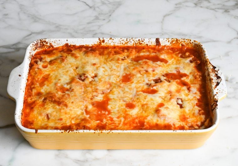 Baking dish of cheesy stuffed shells topped with melted cheese.