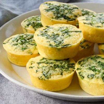Spinach egg bites piled on a plate.