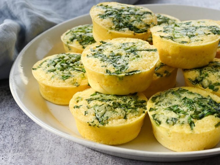 Spinach egg bites piled on a plate.