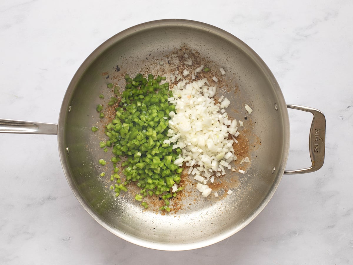 onions and peppers in skillet
