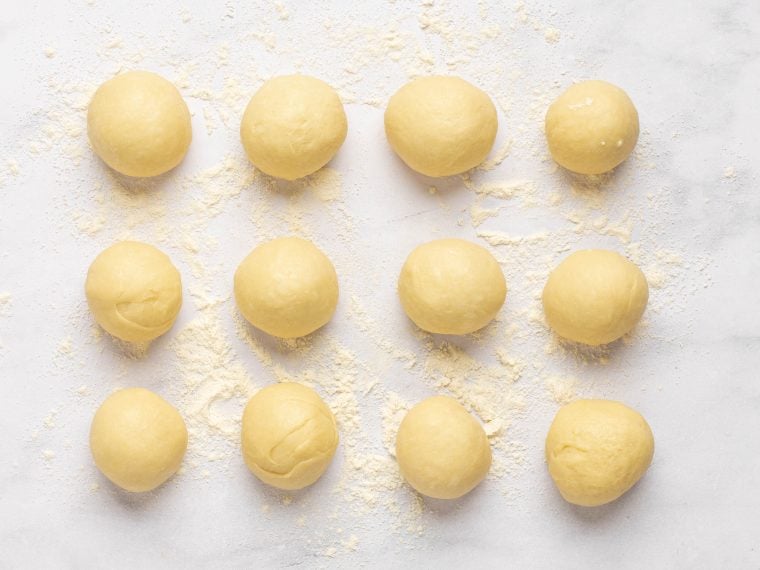 dough divided into 12 pieces and shaped into buns