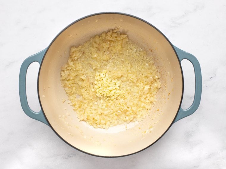 adding garlic to softened shallots in pot