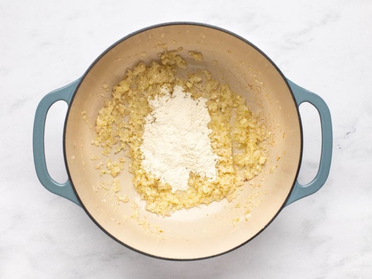 Pile of flour in a Dutch oven with garlic.