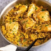 Spoon in a skillet of arroz con pollo.