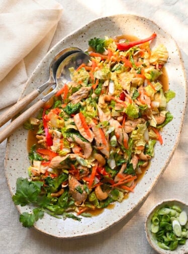 Chinese chicken salad on platter with serving spoons