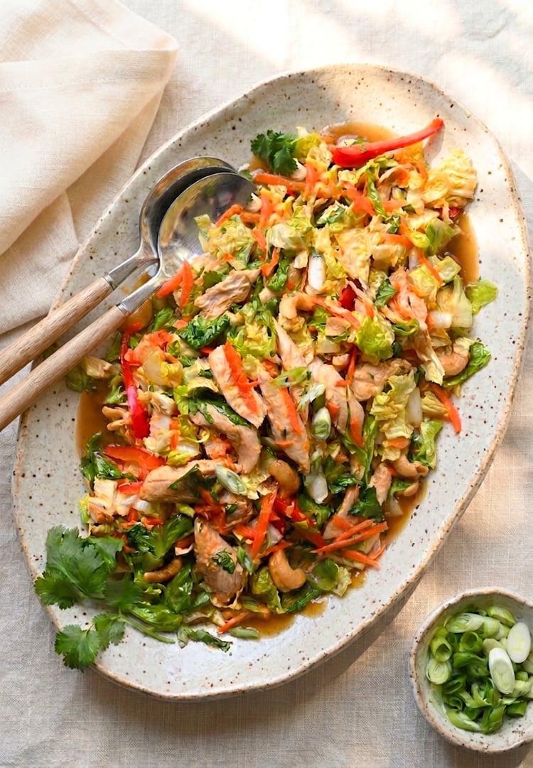 Chinese chicken salad on platter with serving spoons
