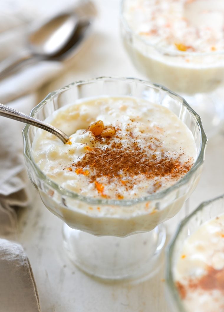 Spoon in a stemmed glass of rice pudding.