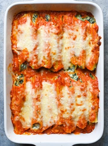 Spinach manicotti in a baking dish.
