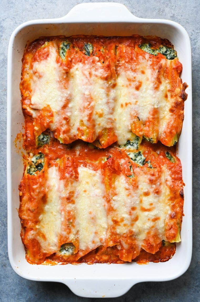 Spinach manicotti in a baking dish.
