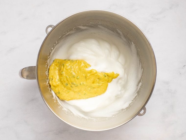 adding some of the soufflé base to the beaten egg whites