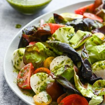 Plate of salad topped with basil vinaigrette.