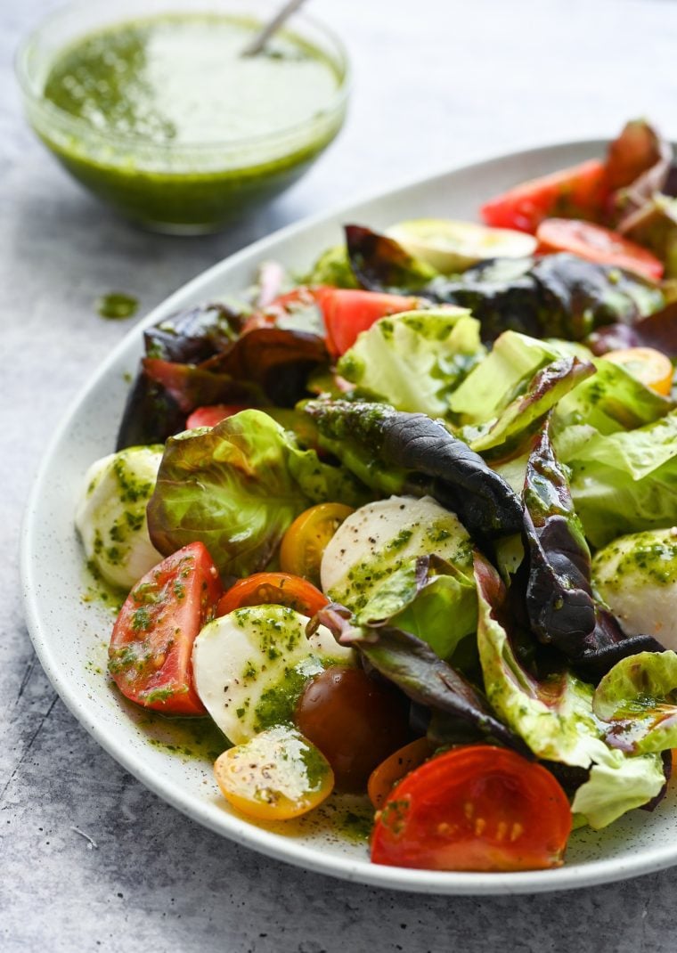 Plate of salad topped with basil vinaigrette.