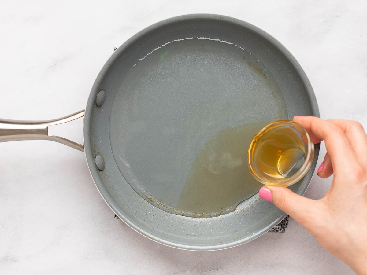 adding rum to water and sugar mixture