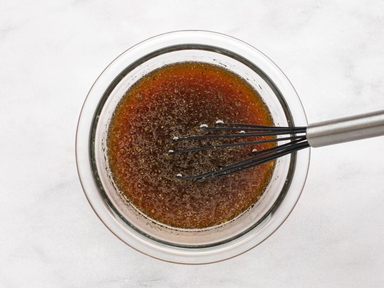 whisking the soy sauce, sugar, water, orange juice, bourbon, sesame oil, and pepper
