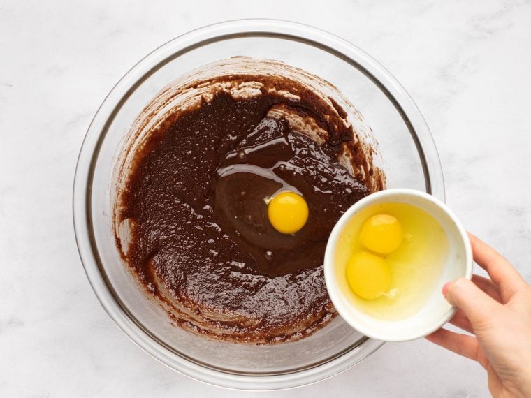adding eggs to bowl